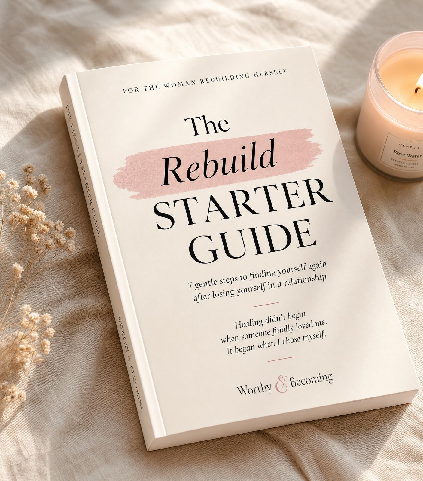 The Rebuild Starter Guide book mockup on a soft cream linen surface with a candle and dried flowers